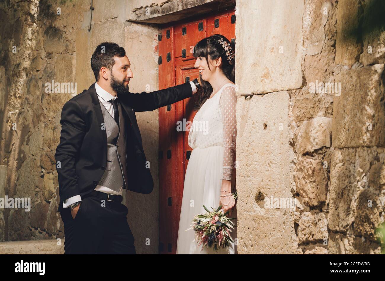 Giovane sposa e sposo in piedi insieme vicino al muro Foto Stock