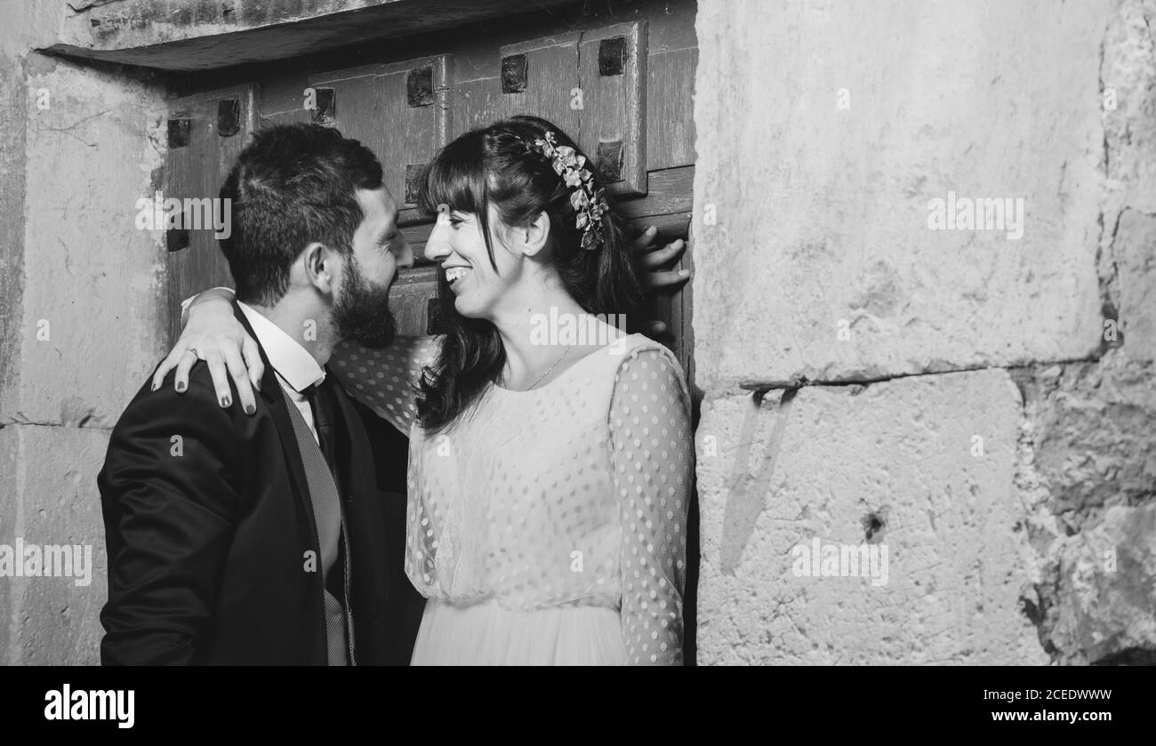 Giovane sposa e sposo in piedi insieme vicino al muro Foto Stock