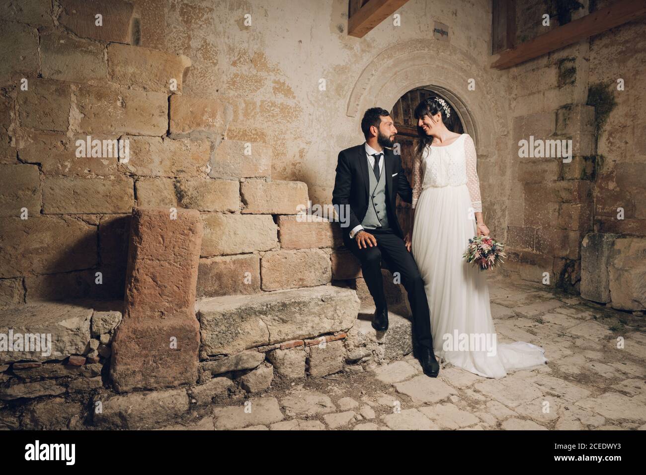 Giovane sposa e sposo in piedi insieme vicino al muro Foto Stock