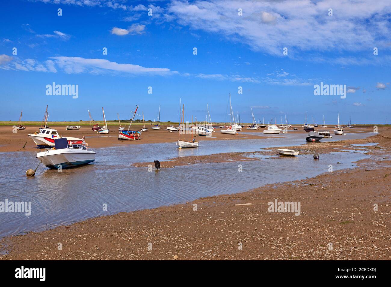 Le barche si sono arenate sul Creek a bassa marea a Brancaster Staithe, Norfolk, Regno Unito Foto Stock
