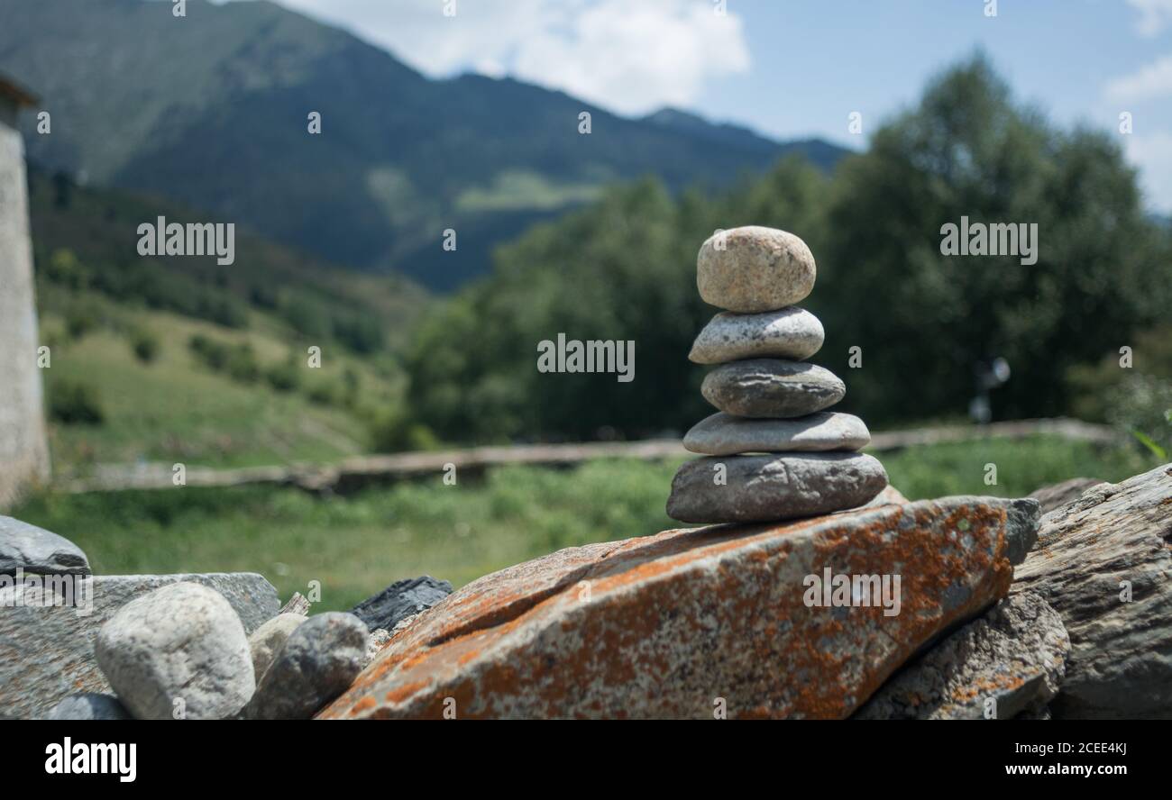 Piccola pila di ciottoli grigi su roccia con sfondo di natura verde dei Pirenei montagne, Spagna Foto Stock