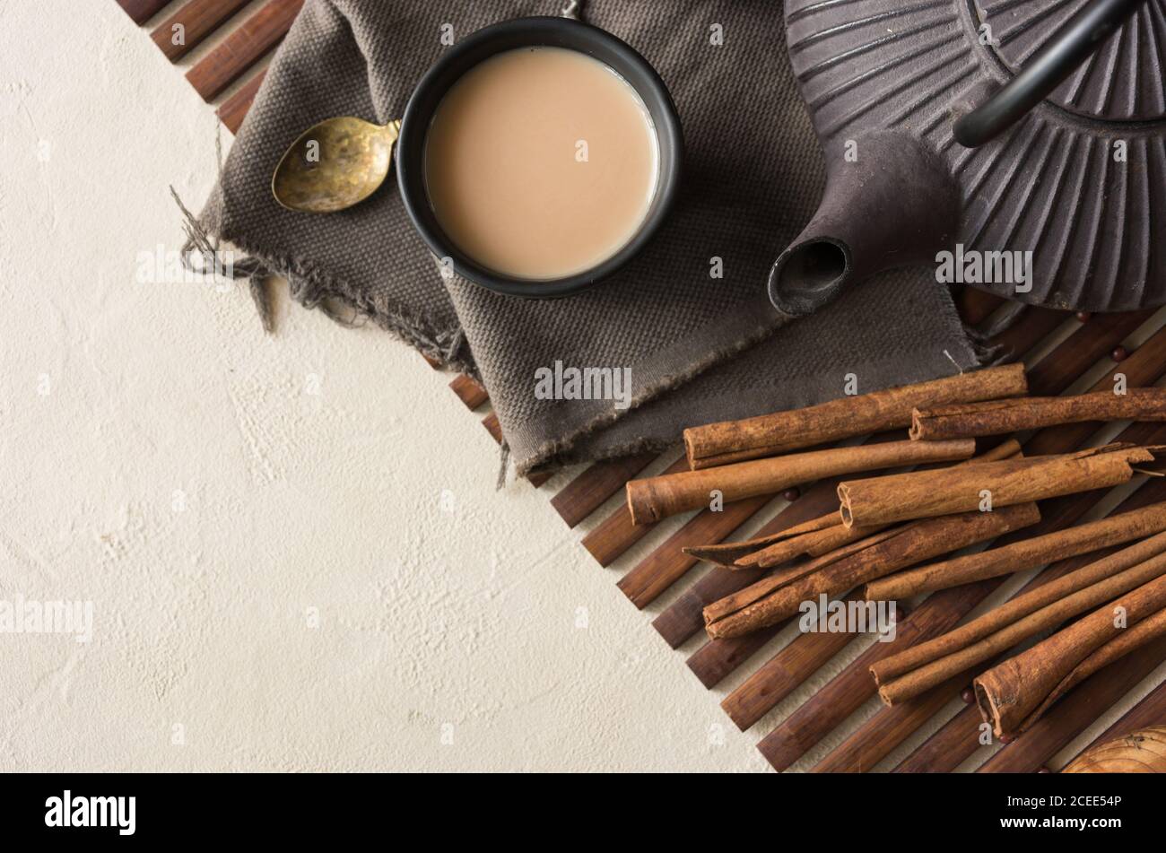 Tazza orientale di tè Chai, i suoi ingredienti con latte, cannella, zenzero, pepe bianco e cardamomo Foto Stock