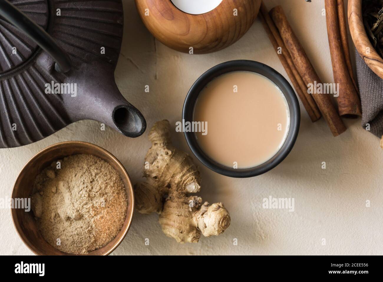 Tazza orientale di tè Chai, i suoi ingredienti con latte, cannella, zenzero, pepe bianco e cardamomo Foto Stock