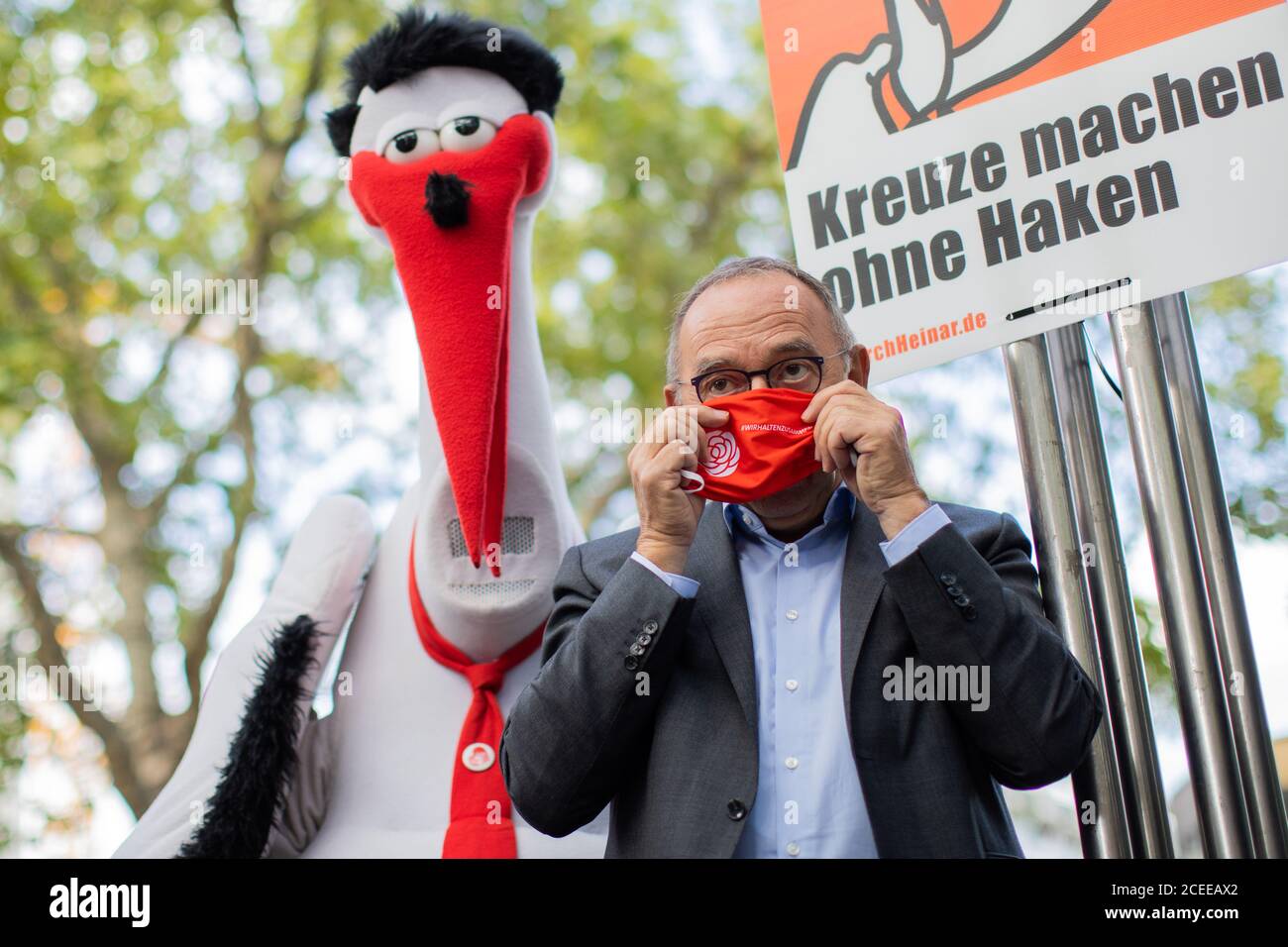 Dortmund, Germania. 01 settembre 2020. Norbert Walter-Borjans, presidente della SPD, appende un poster accanto a Storch Heinar con l'iscrizione "Kreuze machen ohne Haken" (fare croci senza ganci) durante una campagna elettorale durante il viaggio estivo. Storch Heinar è un'etichetta di moda gestita dal Jusos Mecklenburg-Vorpommern come esame satirico del marchio di abbigliamento Thor Steinar. Credit: Rolf Vennenbernd/dpa/Alamy Live News Foto Stock