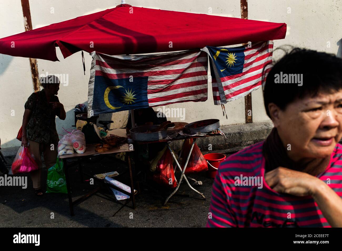 La gente in paese esotico sulla strada con piccolo stalla che vende le cose differenti. Foto Stock