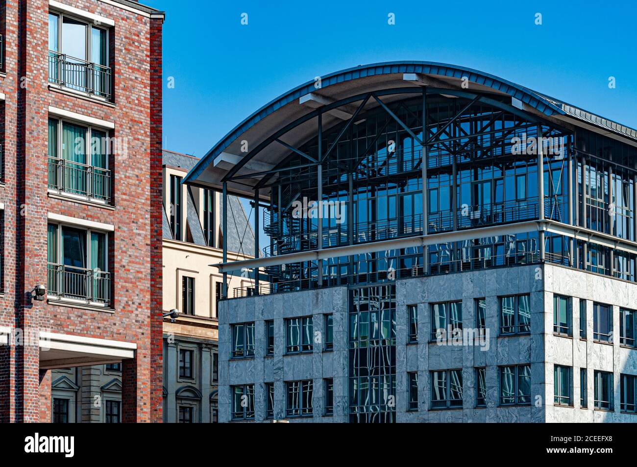 Città del centro di Amburgo con edifici aziendali. Vecchio muro di mattoni con finestre aperte in primo piano. Tetto semicircolare di moderno edificio in marmo Foto Stock