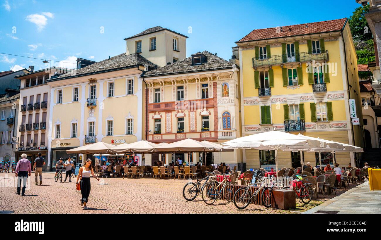 Bellinzona Switzerland , 30 giugno 2020 : Piazza pedonale con case colorate e persone al bar terrazza all'aperto su Piazza Collegiata nella vecchia Bellinzo Foto Stock