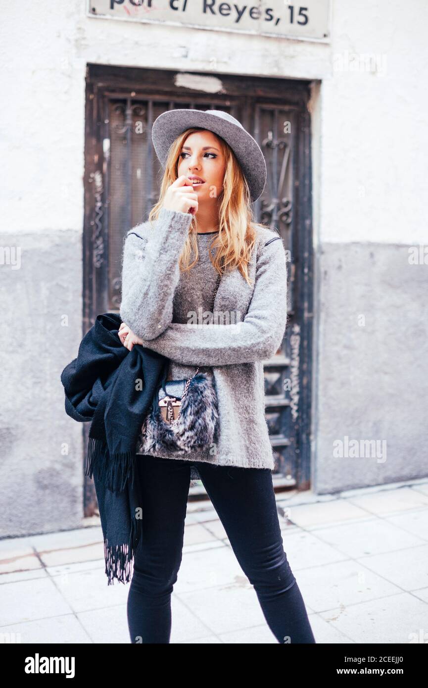 Ritratto di giovane donna bionda che indossa cappello e sciarpa nelle strade di madrid Foto Stock