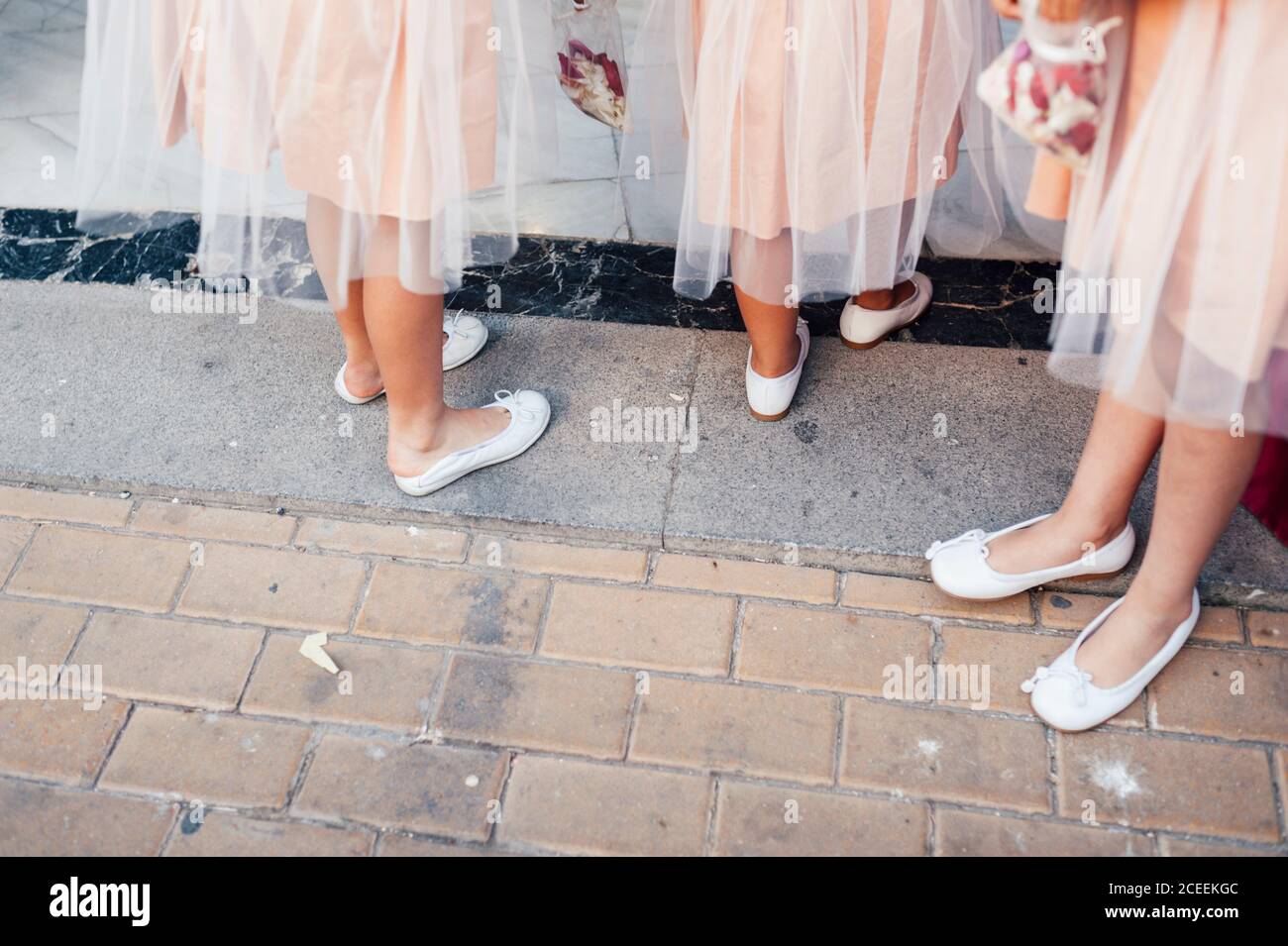 Ritaglia bridesmaid irriconoscibili negli stessi vestiti in piedi sul marciapiede. Foto Stock