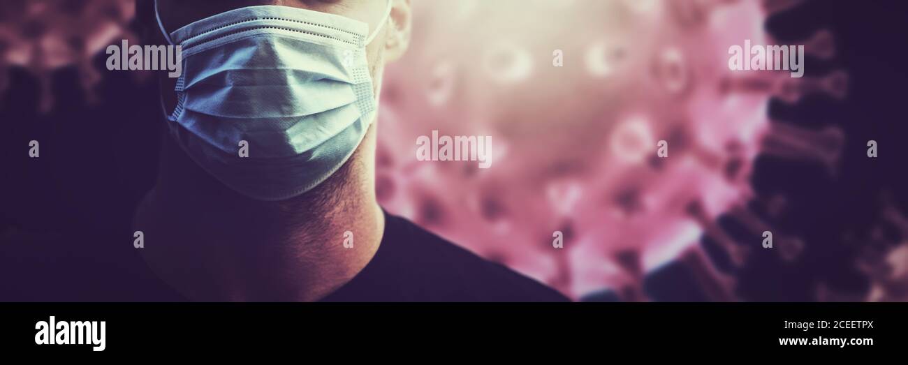 coronavirus covid-19 pandemic - uomo con maschera facciale sullo sfondo delle cellule del virus. spazio di copia del banner Foto Stock