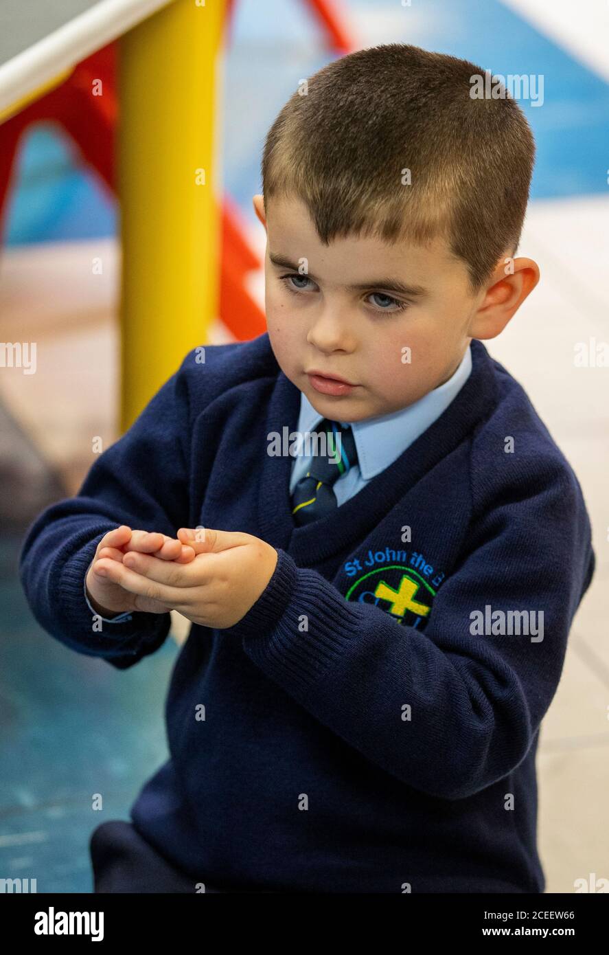 Ronan Girvan mimicante a lavarsi le mani mentre guarda la sfida del lavaggio a mano di Baby Shark il suo primo giorno di P1 alla St John the Baptist Primary School nella parte ovest di Belfast, Poiché quasi tutte le scuole si sono riaperte e oltre 300,000 studenti sono tornati a scuola in Irlanda del Nord per la prima volta da metà marzo. Foto Stock
