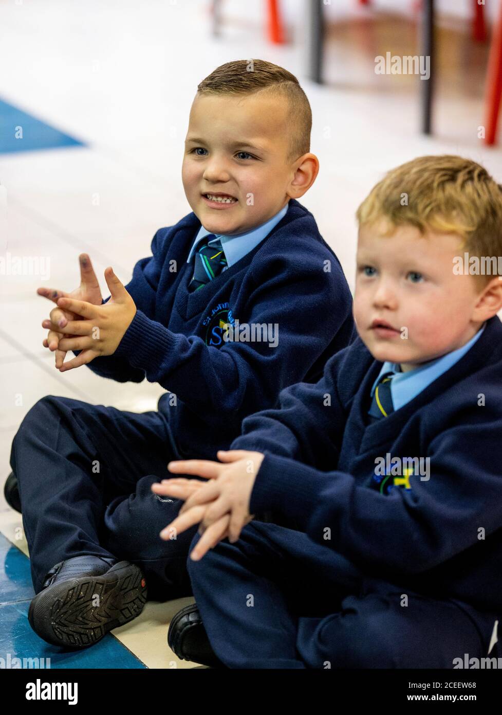 Leo di Vecsi (a sinistra) e Oisin Hicks mimano lavarsi le mani mentre guardano il Baby Shark Hand Wash Challenge il primo giorno di P1 alla St John the Baptist Primary School a Belfast ovest, Poiché quasi tutte le scuole si sono riaperte e oltre 300,000 studenti sono tornati a scuola in Irlanda del Nord per la prima volta da metà marzo. Foto Stock