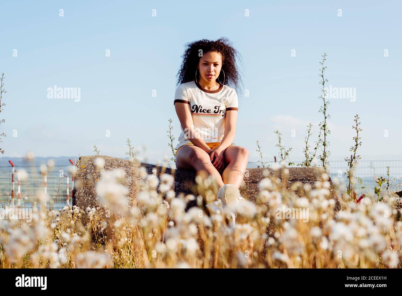 Donna Afro-americana rilassante sul log Foto Stock
