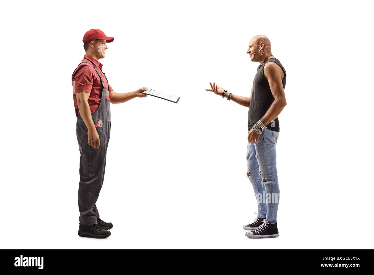 Scatto di profilo a lunghezza intera di un corriere maschio che consegna un documento ad un hipster ragazzo isolato su sfondo bianco Foto Stock