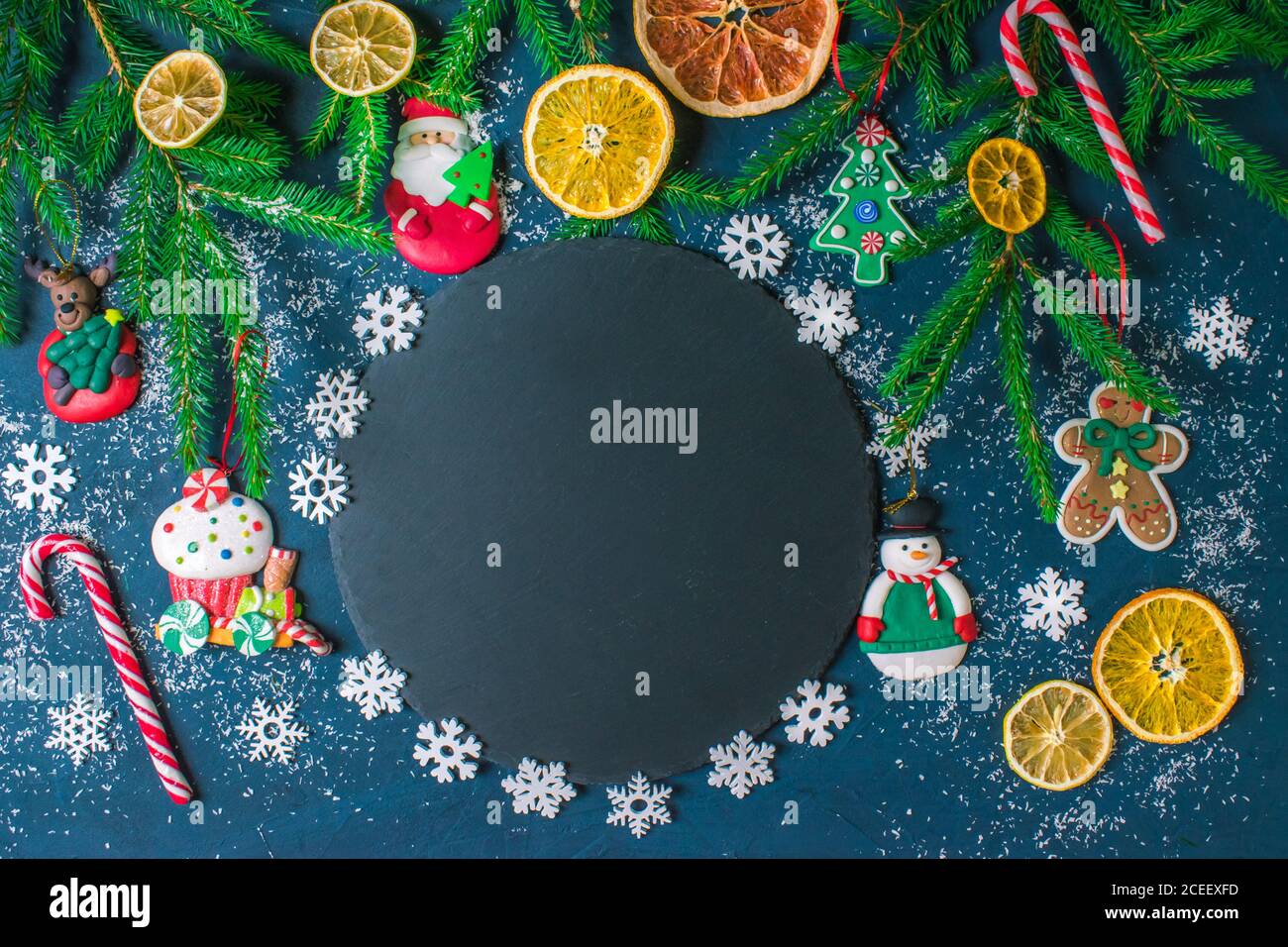 Cornice di Natale con decorazioni di rami di albero di Natale e giocattoli di Natale con palle di neve. Foto Stock