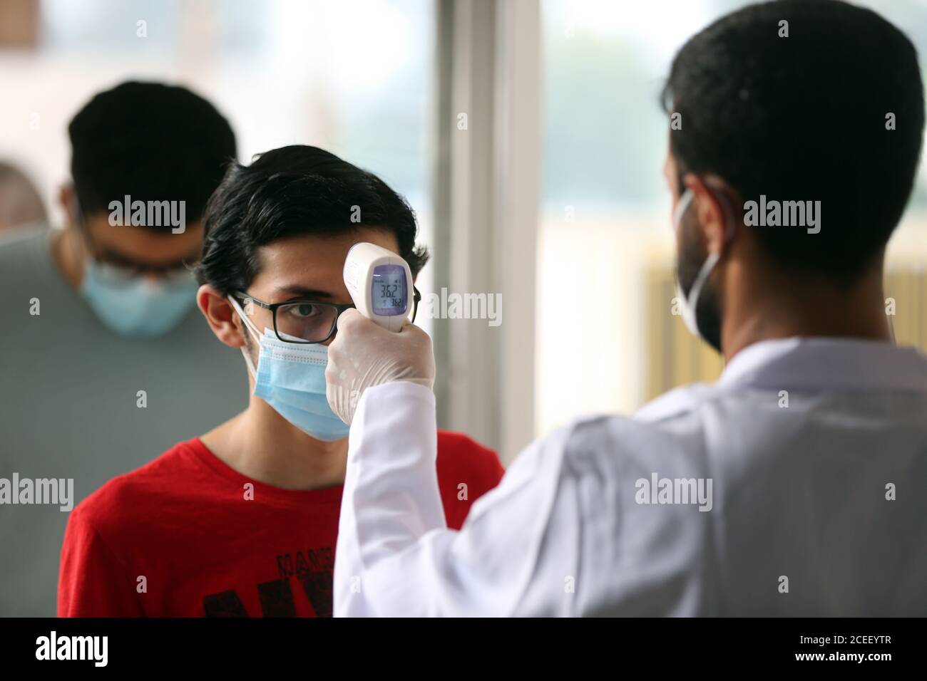 Baghdad. 1 settembre 2020. Uno studente riceve il controllo della temperatura prima di entrare in un sito di esame a Baghdad, Iraq, il 1 settembre 2020. Gli studenti delle scuole superiori in Iraq hanno effettuato gli esami finali nell'ambito di rigorose misure sanitarie a causa della pandemia COVID-19. Credit: Xinhua/Alamy Live News Foto Stock