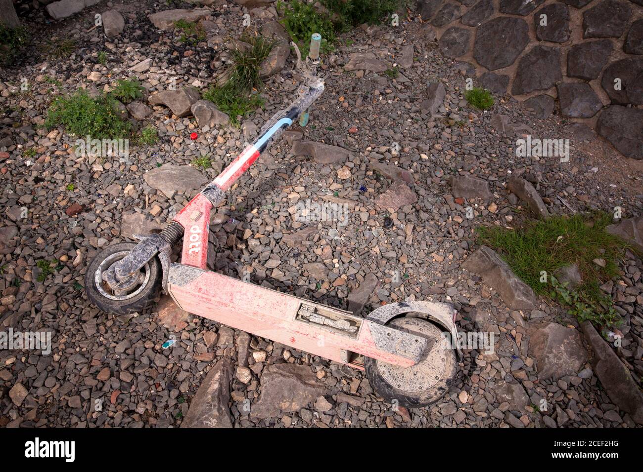 Uno scooter elettrico Dott sporco recuperato dal Reno si trova sulle rive del Reno, Colonia, Germania. Aus dem Rhein geborgener Dott Elektroscooter Foto Stock