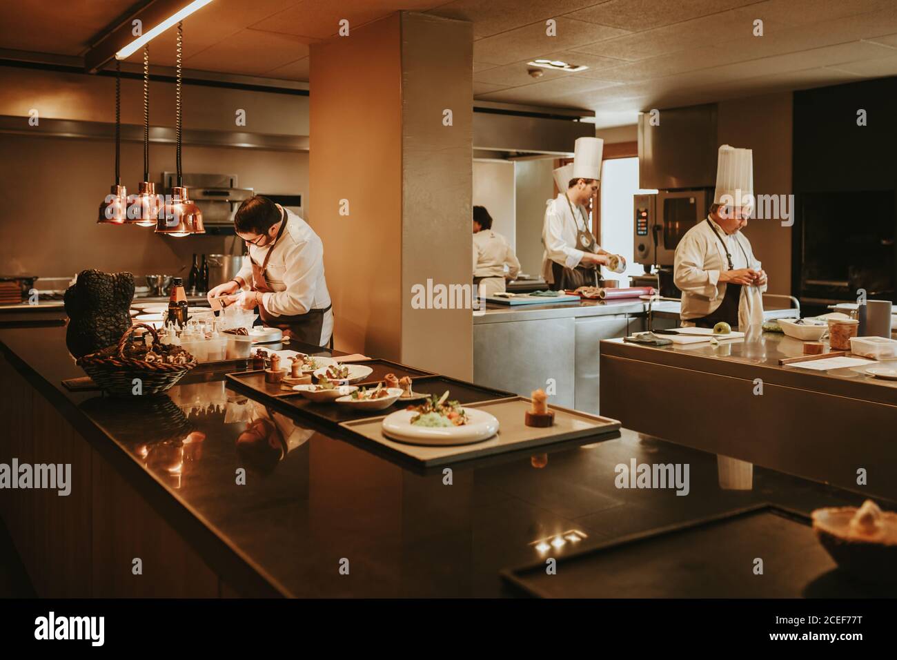 Il personale del ristorante in cucina serve i piatti. Scatto orizzontale all'interno. Foto Stock