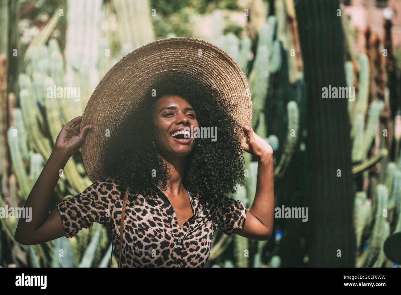 Donna allegra con un cappello di paglia in un bel giardino Foto Stock