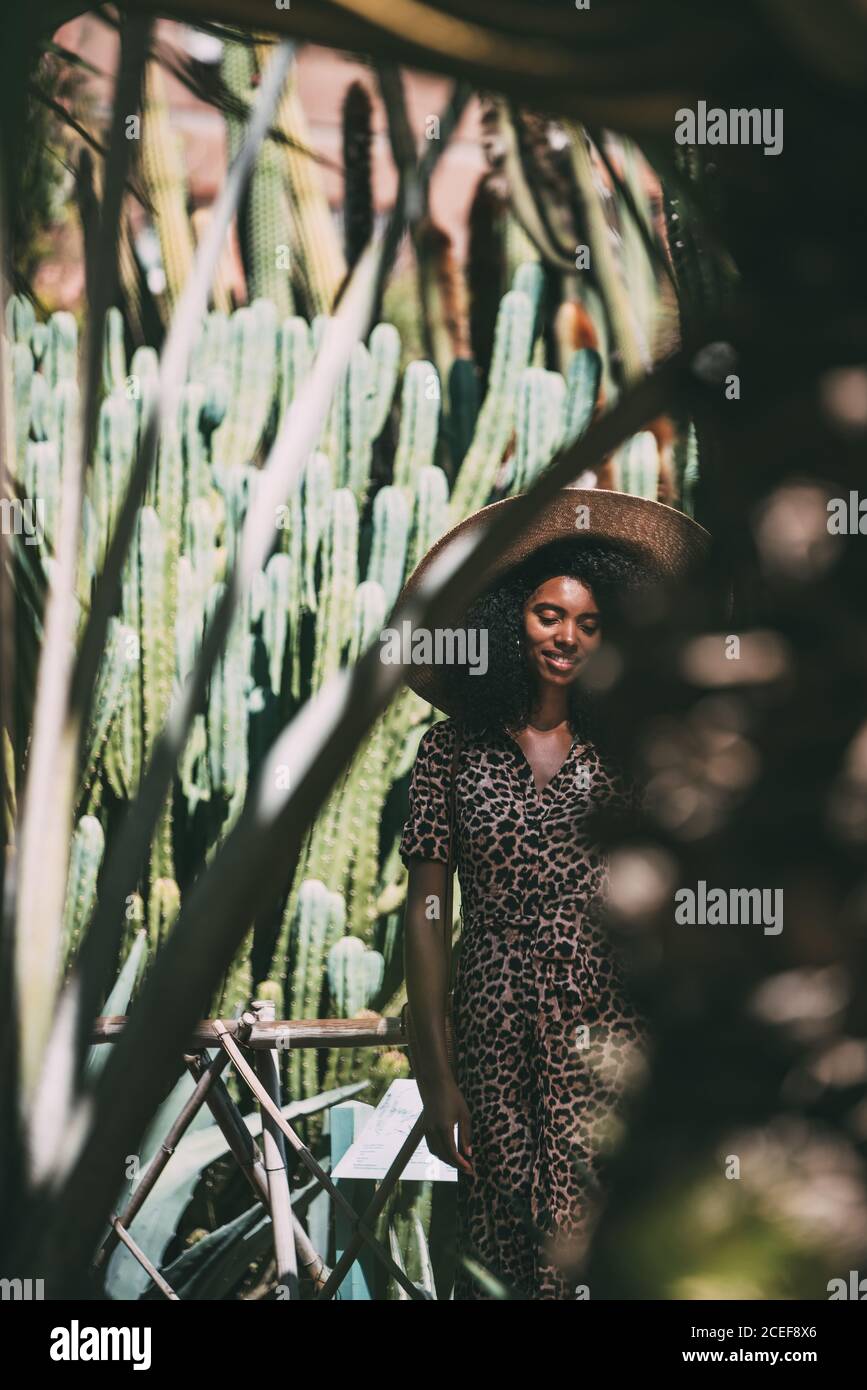 Donna con un cappello di paglia in un bel giardino godendo il momento Foto Stock