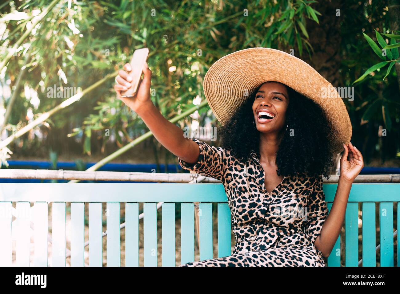 Donna seduta in un bel giardino che prende un selfie sopra il telefono cellulare Foto Stock