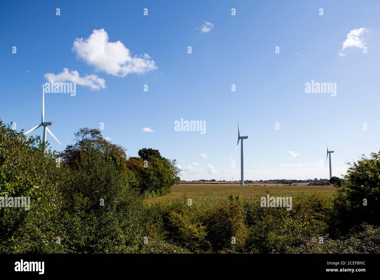 Aerogeneratore contro il cielo blu nuvoloso Foto Stock