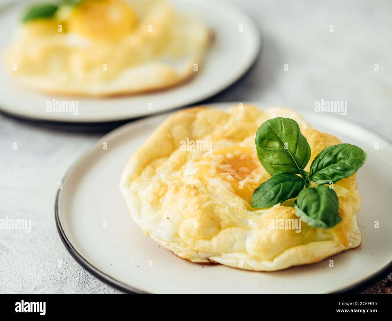 Uova di nuvola soffici. Cibo alla moda - forno cuocere uova strapazzate con albume d'uovo montato e tuorlo intero sul piatto Foto Stock