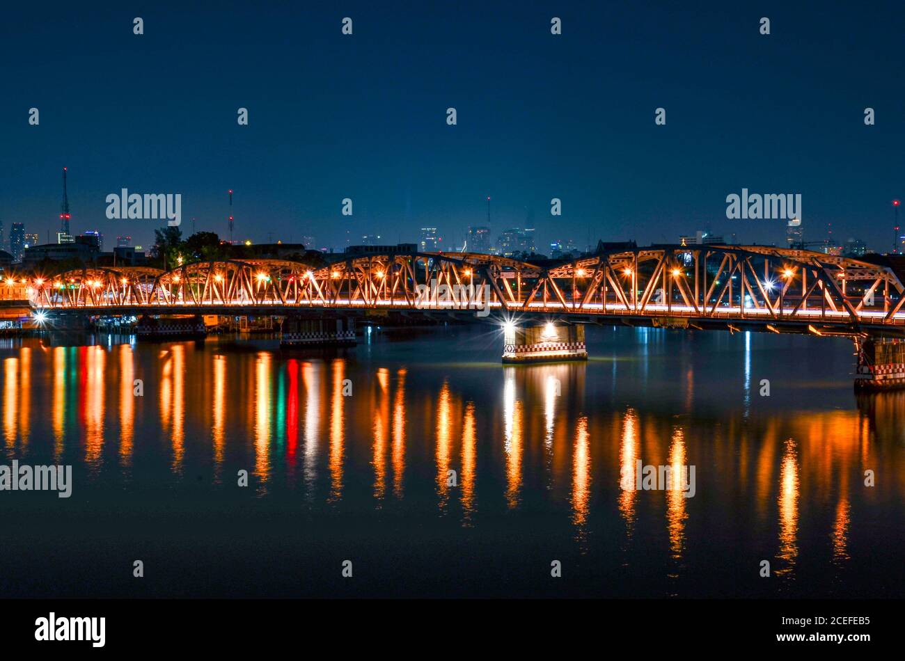 Krung Thon Buri Bridge a Bangkok, Thailandia. La foto è stata scattata di notte. Riflessi di luci e linee di velocità da auto sono visibili. Foto Stock