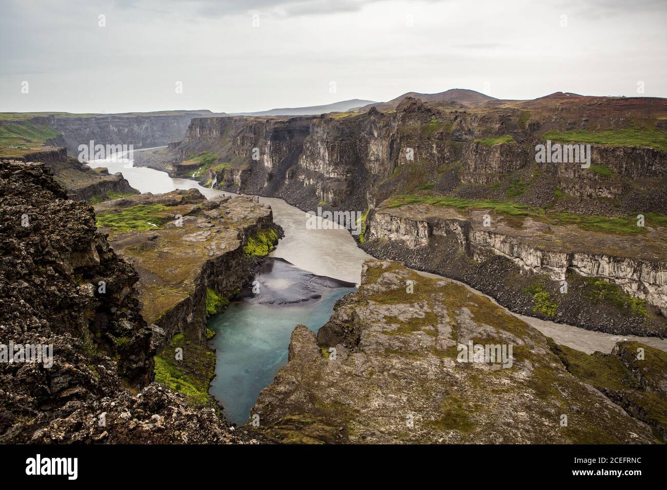 Dall'alto della pittoresca valle con colline di pietra e. Acqua corrente in Islanda Foto Stock