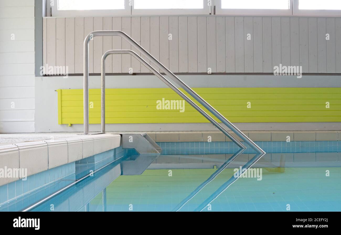Scale metalliche in una piscina interna Foto Stock