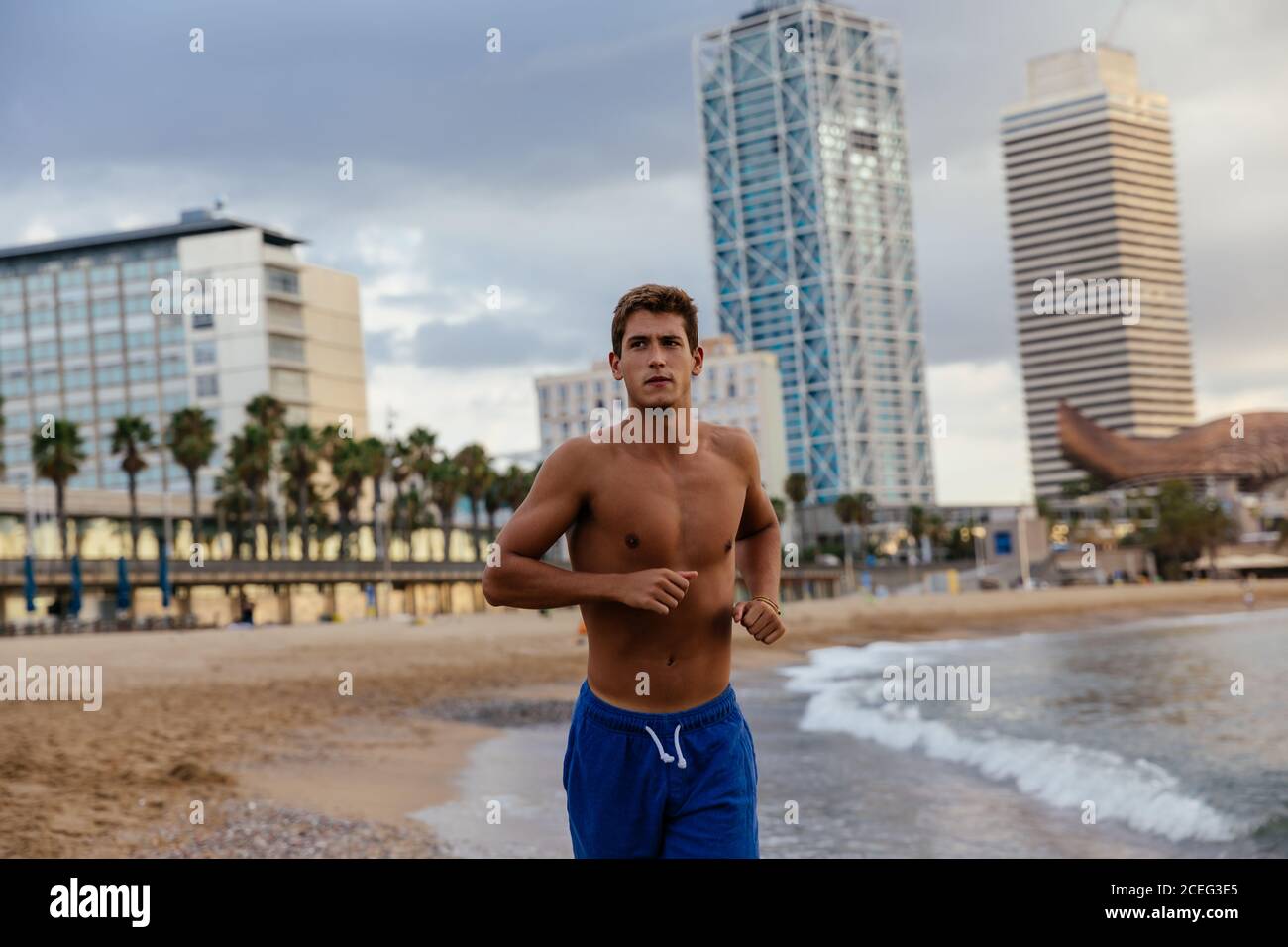 Giovane uomo che corre sulla riva. Foto Stock