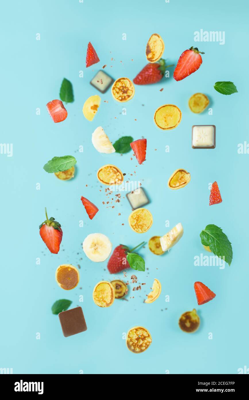 minitola per cereali con fragole fresche, banana, cioccolato, menta di cocco. tendenza all'autoisolamento. levitazione di minuscoli pancake Foto Stock