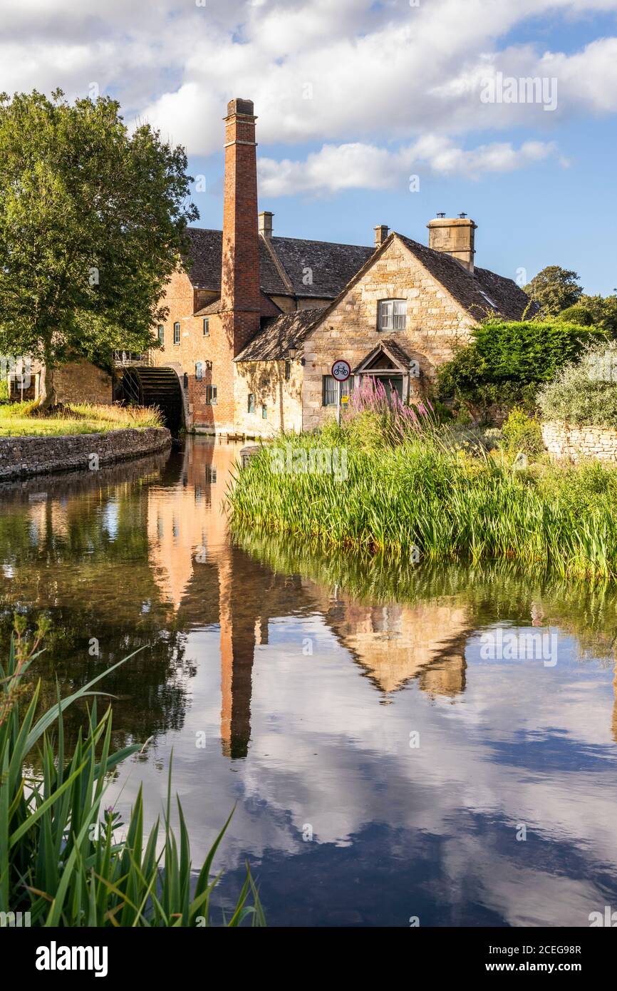 Luce notturna sul vecchio mulino e cottage in pietra accanto al River Eye nel villaggio Cotswold di Lower Slaughter, Gloucestershire, Inghilterra Regno Unito Foto Stock