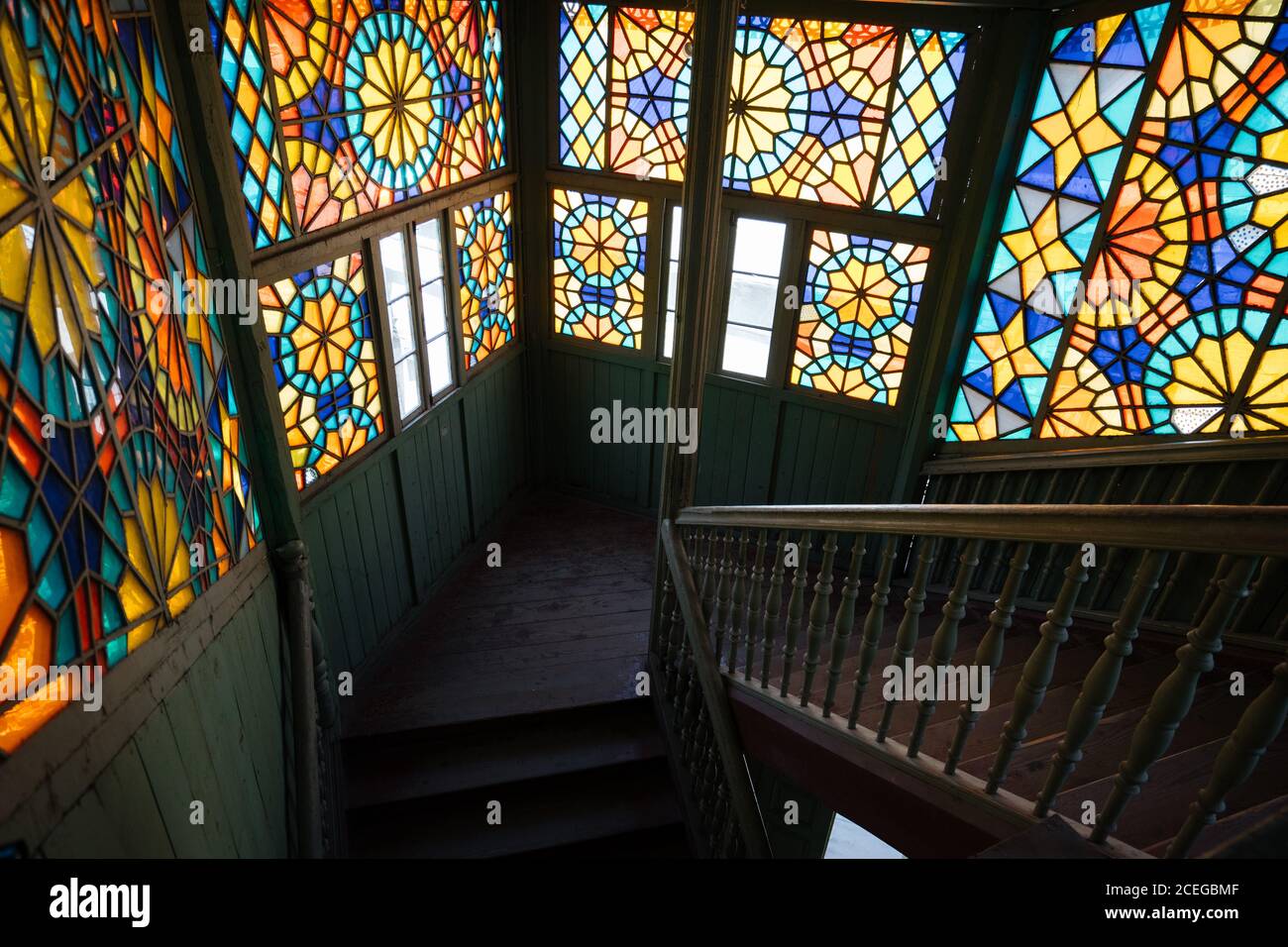 Elegante pannello colorato di vetro su scala vintage in vecchio shabby edificio in legno nella luce del giorno Foto Stock