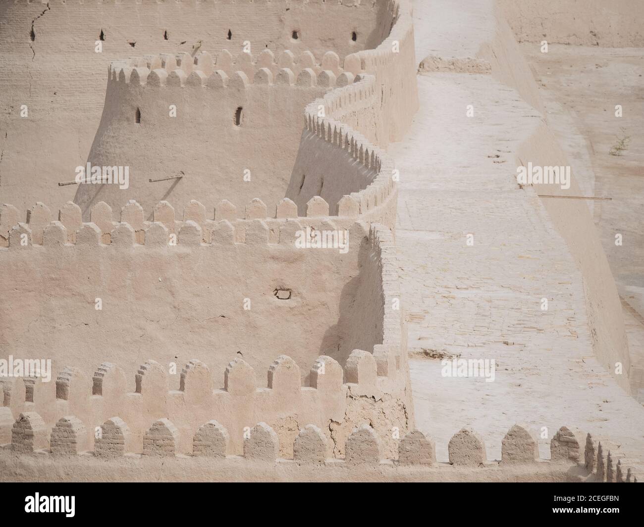 Vista prospettica di un muro di pietra senza fine con passaggio pedonale in cima alla luce del sole, Uzbekistan Foto Stock