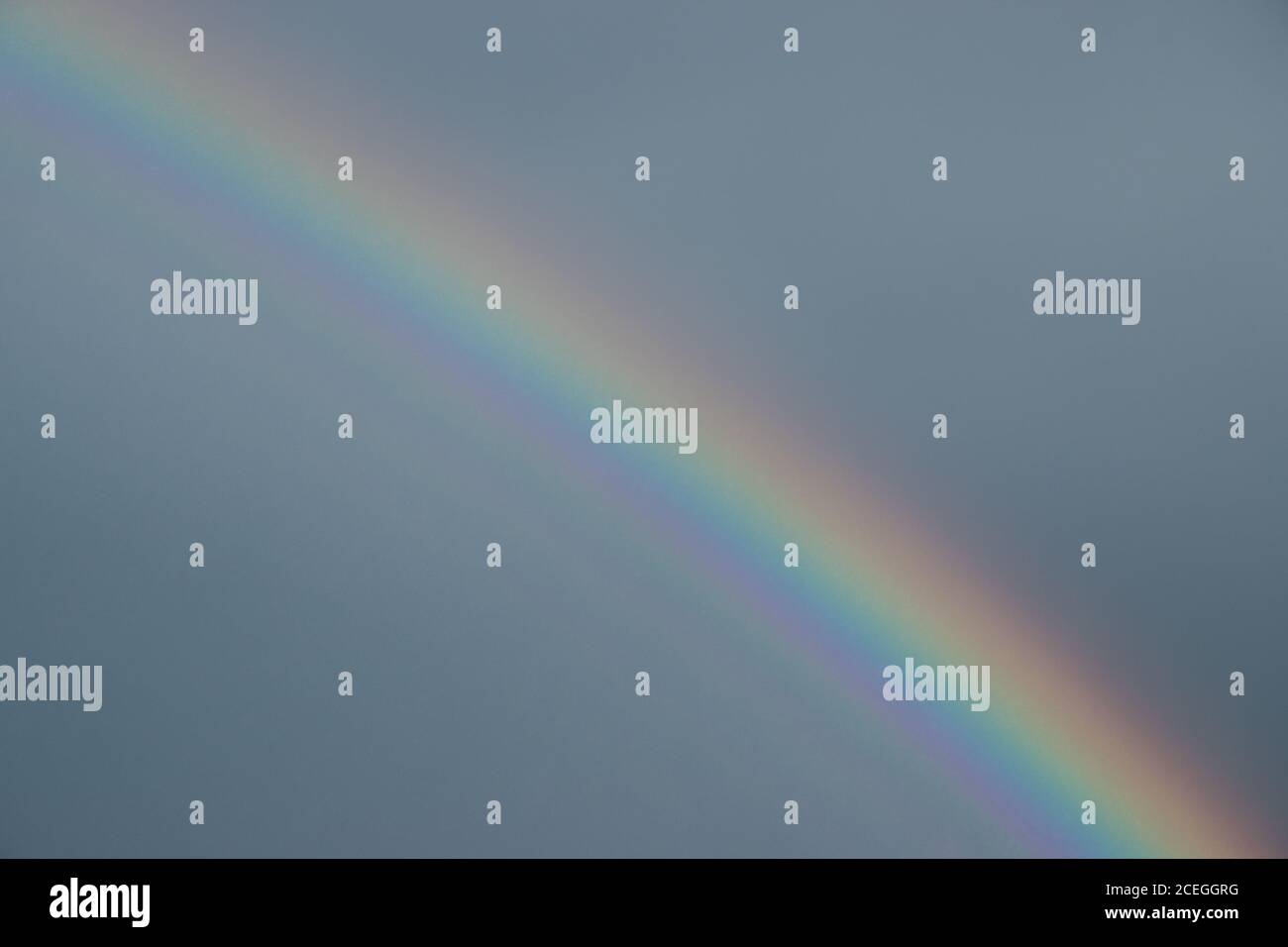 Sfondo di arcobaleno colorato nel cielo blu. Foto Stock