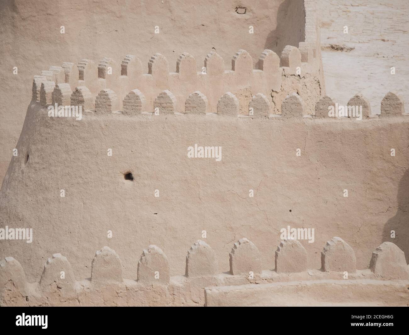 Vista prospettica di un muro di pietra senza fine con passaggio pedonale in cima alla luce del sole, Uzbekistan Foto Stock