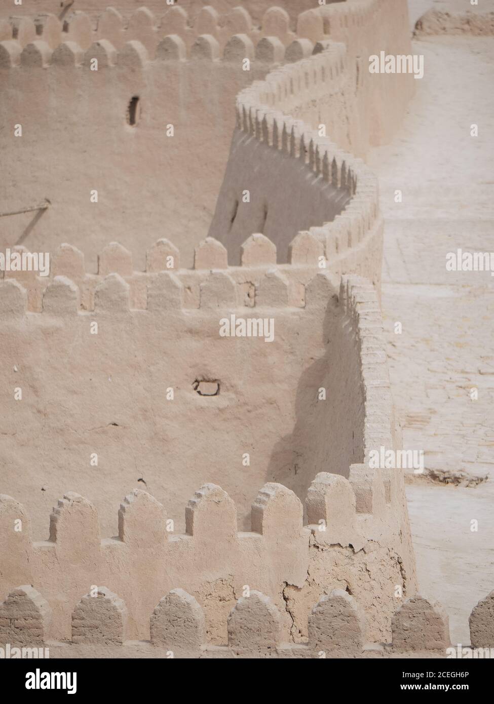 Vista prospettica di un muro di pietra senza fine con passaggio pedonale in cima alla luce del sole, Uzbekistan Foto Stock