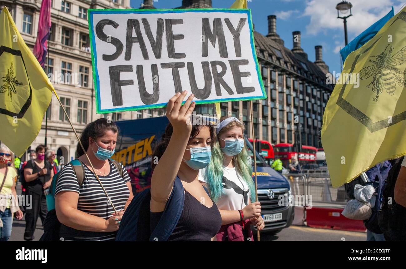 Estinzione i manifestanti della ribellione marciano alle Camere del Parlamento, una delle quali porta un segno che recita ‘SSalva il mio futuro’, durante le manifestazioni del 2020. Foto Stock