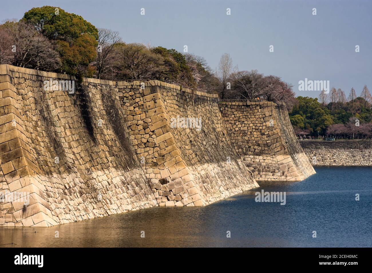 Mura del castello di Osaka con un fossato d'acqua che lo circonda, a Osaka, Giappone Foto Stock