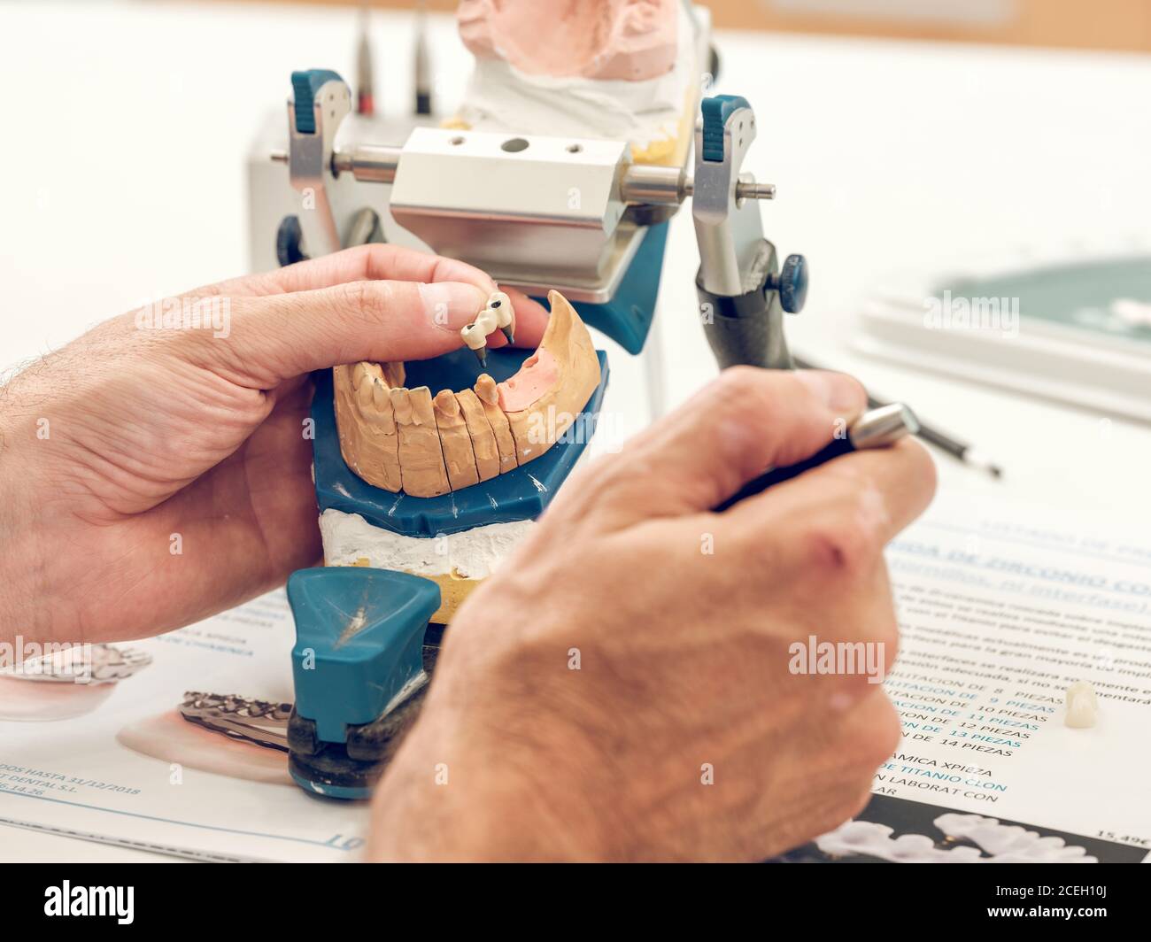 Mani di dentista che fanno una dentiera in piedi con attrezzatura speciale Foto Stock