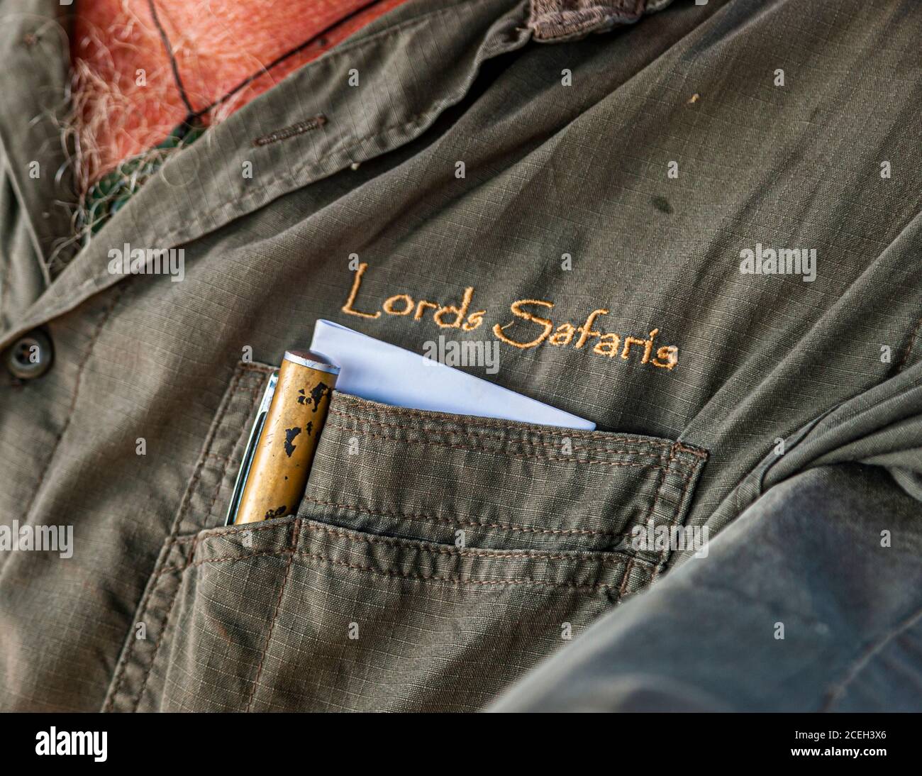 La scritta ricamata "Lords Safaris" appare sulla tasca della camicia della guida, che tiene una penna e un blocco appunti – il marchio dell'azienda Sab Lord Safaris, visto durante una visita guidata dell'outback australiano. Foto Stock