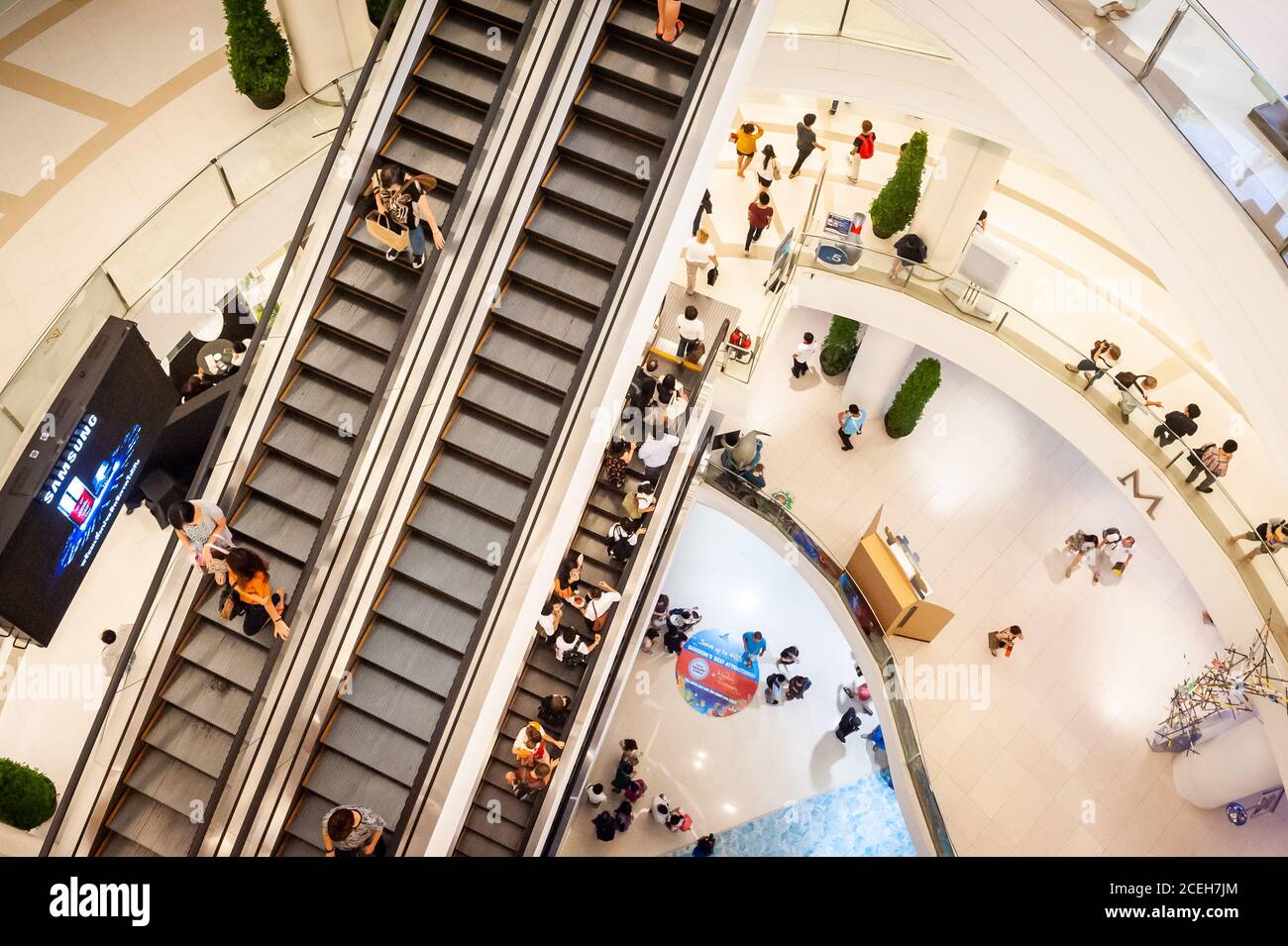 Guardando verso il basso le scale mobili e i piani inferiori del gigantesco centro commerciale o centro commerciale Siam Paragon a Bangkok, Thailandia. Foto Stock