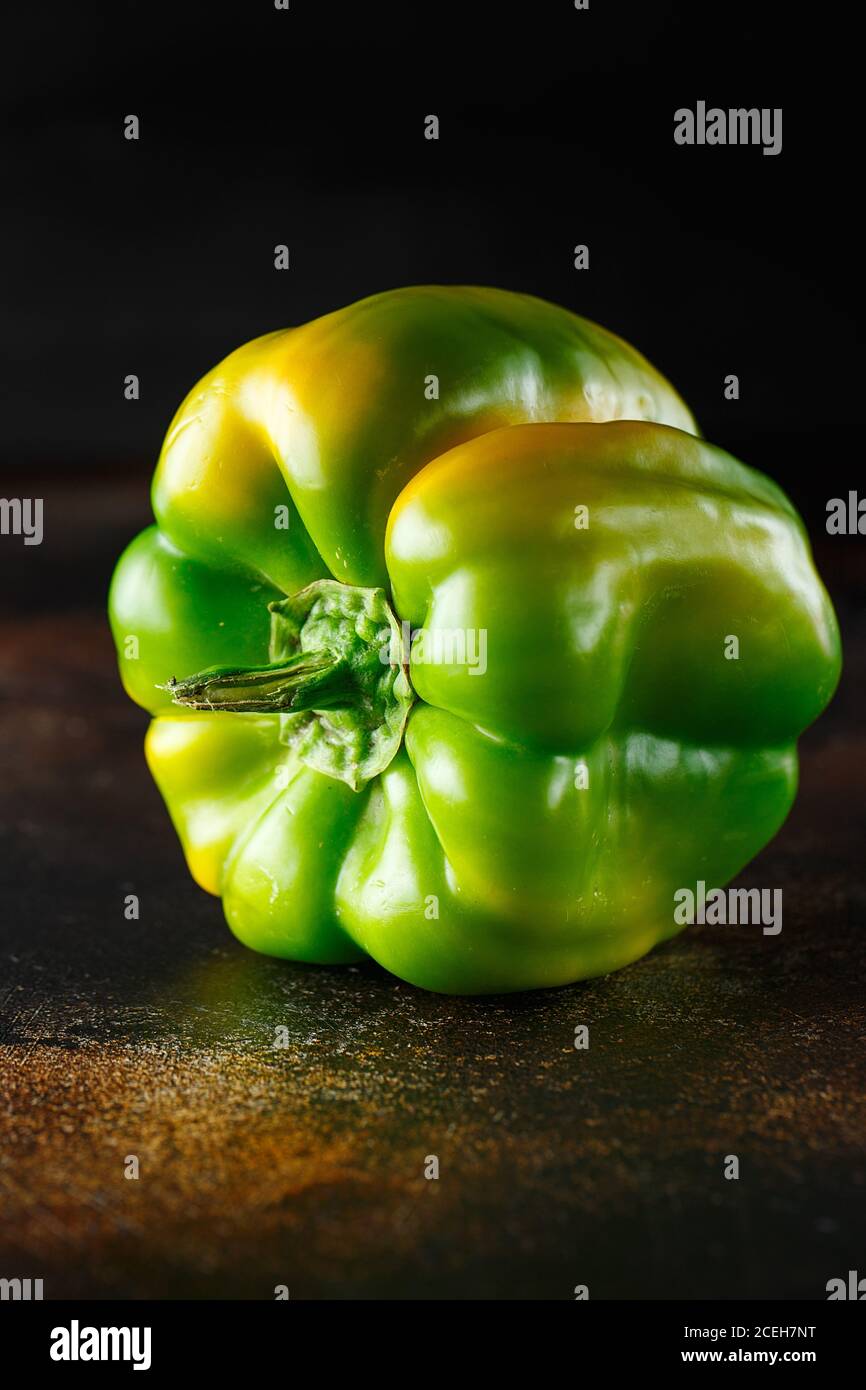 Peperone verde dolce su fondo scuro. Peperone verde giallo fresco (capsicum) Foto Stock