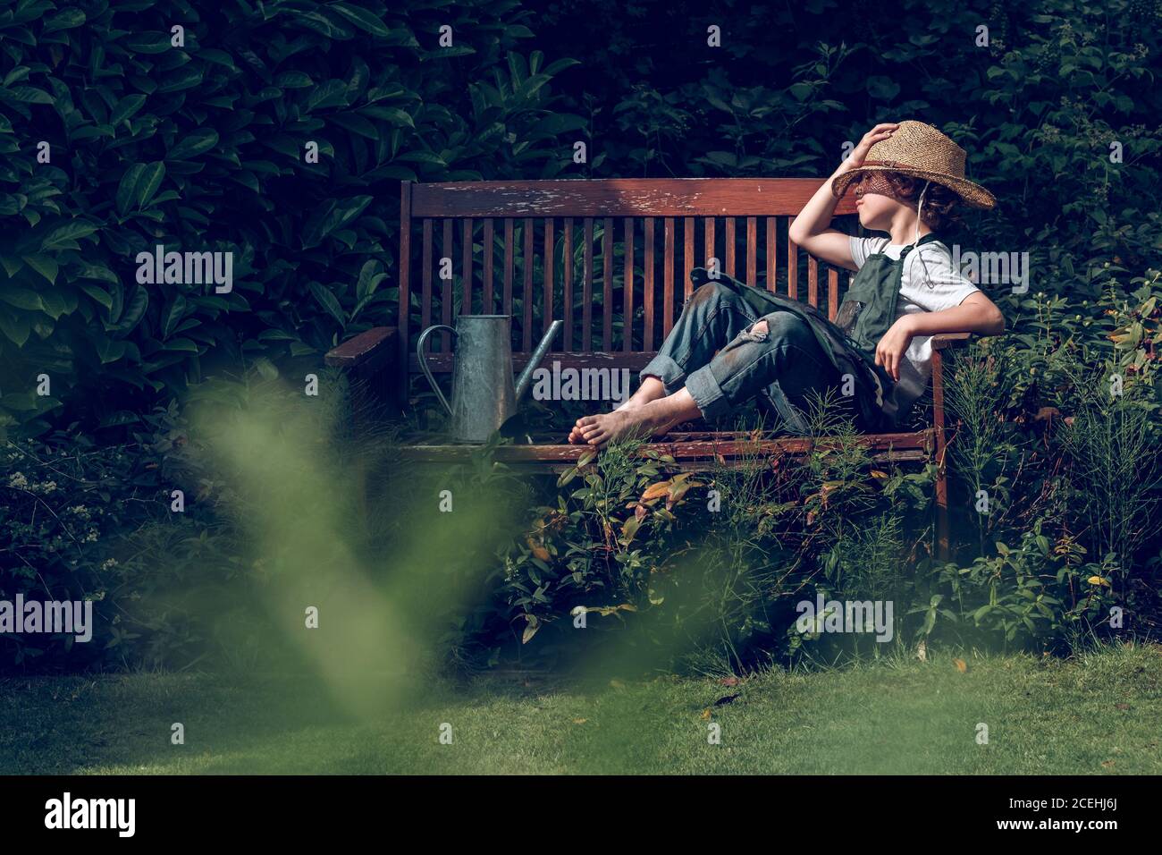 Ragazzo assonnato che si riposa sulla panca Foto Stock