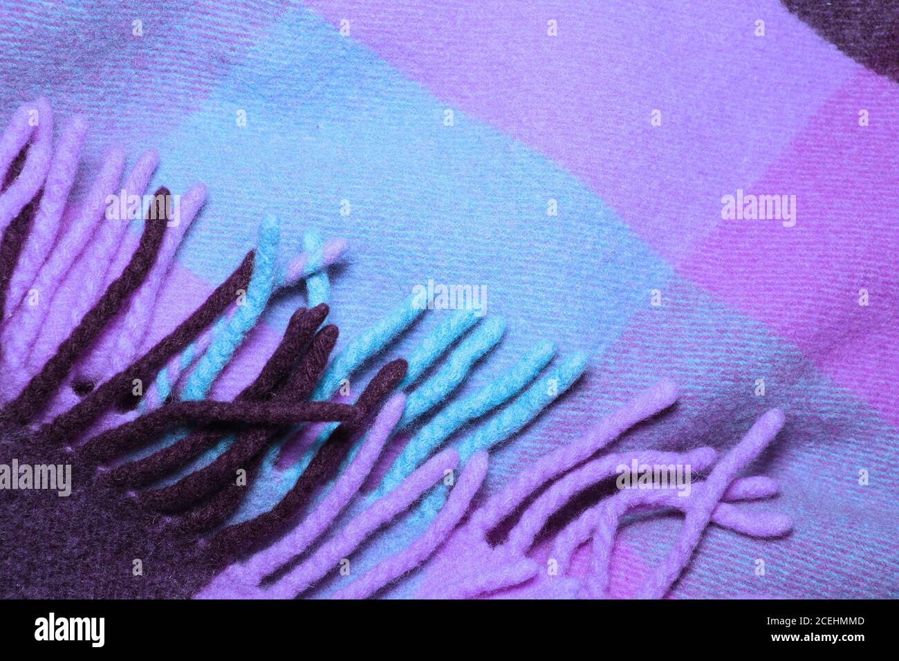 Coperta in lana d'alpaca morbida e calda con frangia. Macro shot in lana di lana e viola. Tessuto di lana con frangia. Coperta di lana Foto Stock