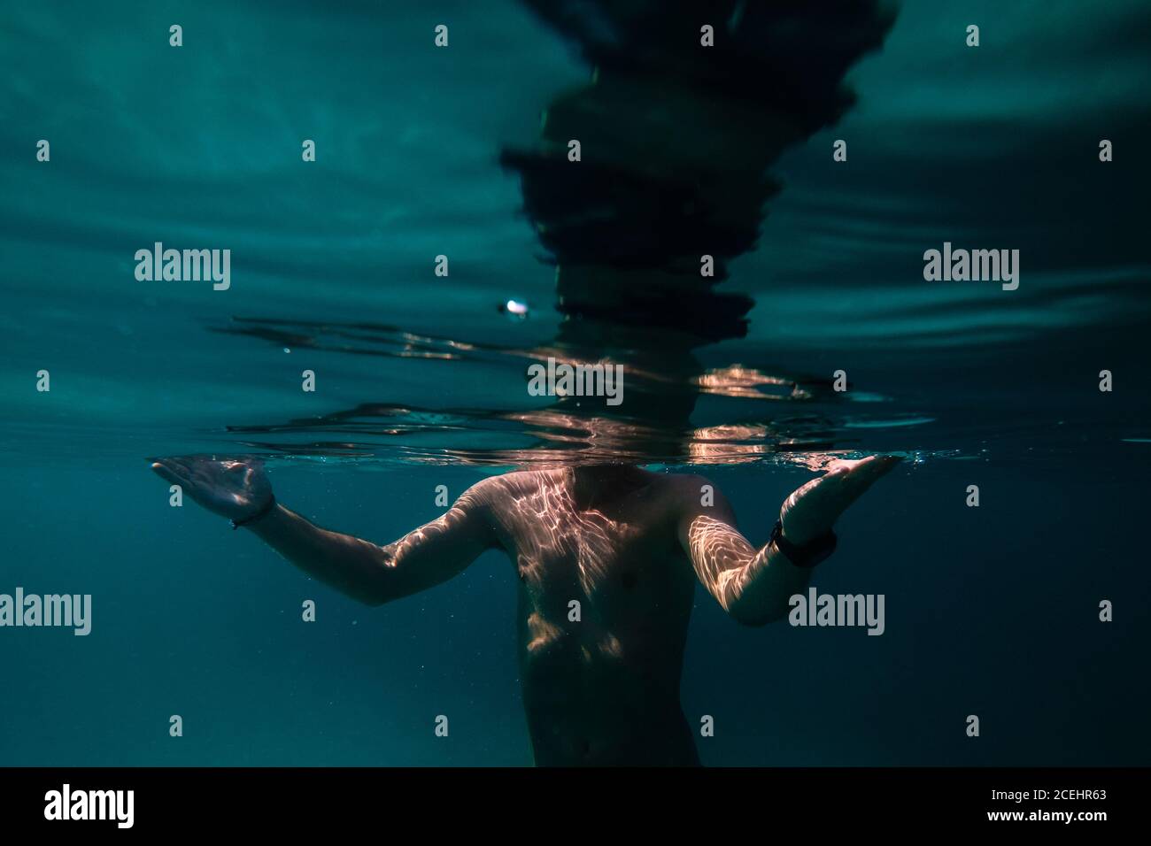 Crop vista dell'uomo con orologio nuotare in azzurro ondulato mare Foto Stock