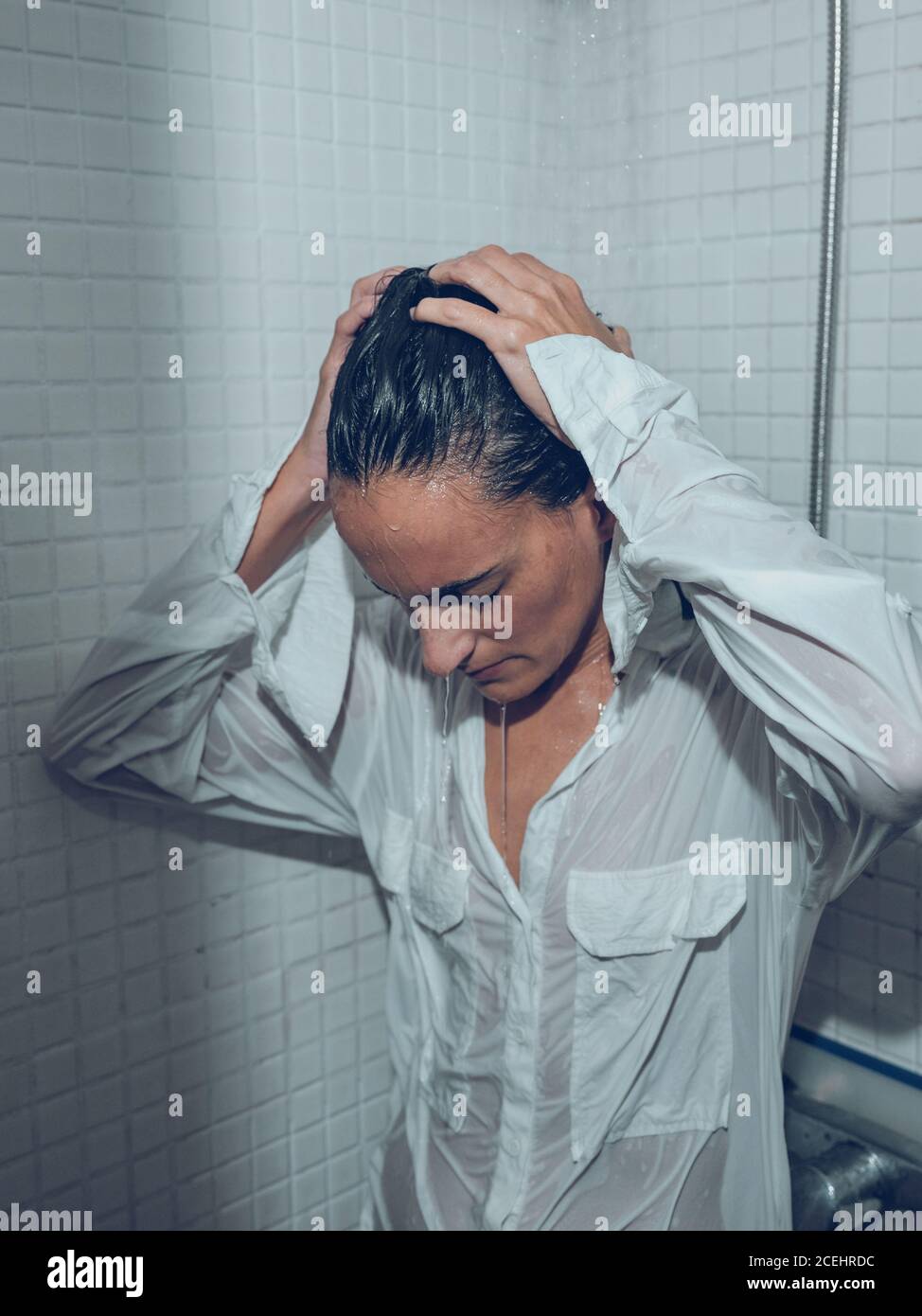 Donna vestita bagnata nella doccia Foto stock - Alamy