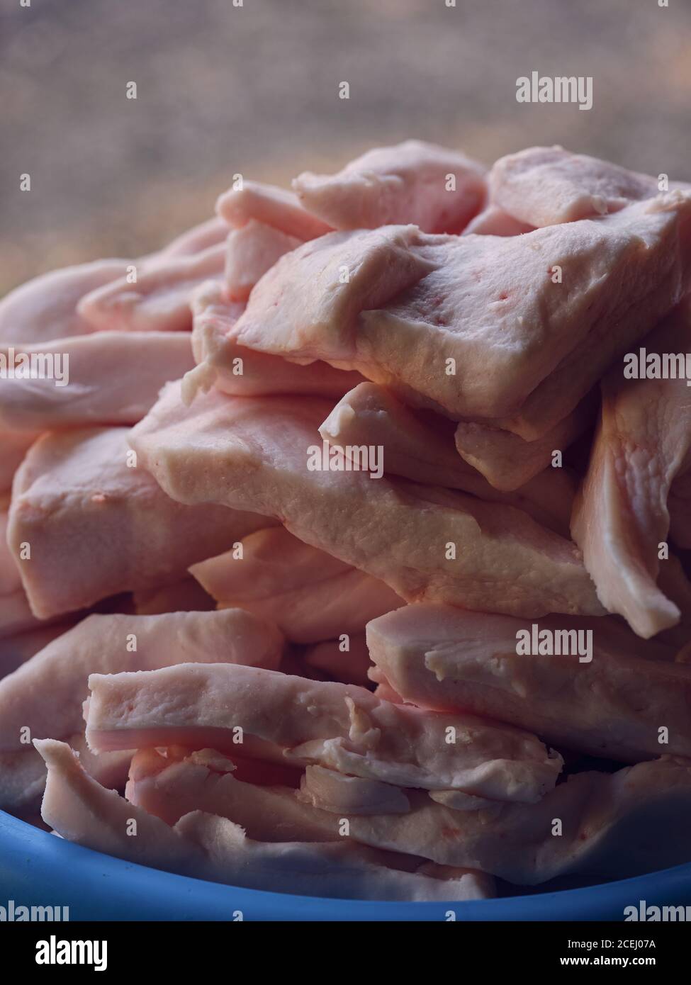 Cumulo di pezzi di grasso animale fresco giacente in plastica bacino su sfondo sfocato Foto Stock