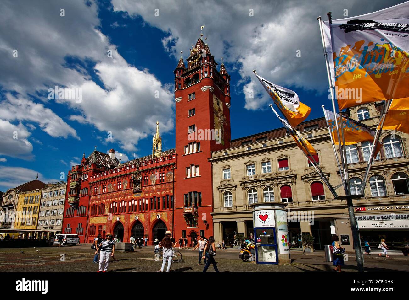 Marktplatz, grande piazza, Rathaus, Municipio, edificio ornato rosso, torre ornata, dipinti, statue, orologio, bandiere battenti, persone, Europa, Basilea; Switz Foto Stock